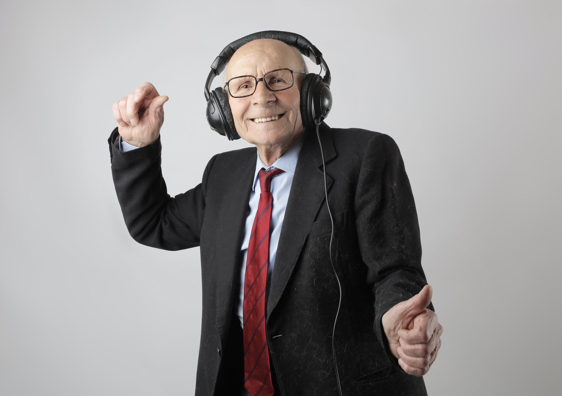 cheerful elderly man listening to music in headphones
